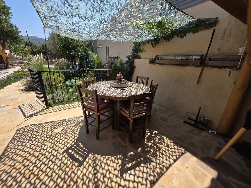 Round dining table for six under a shade sail