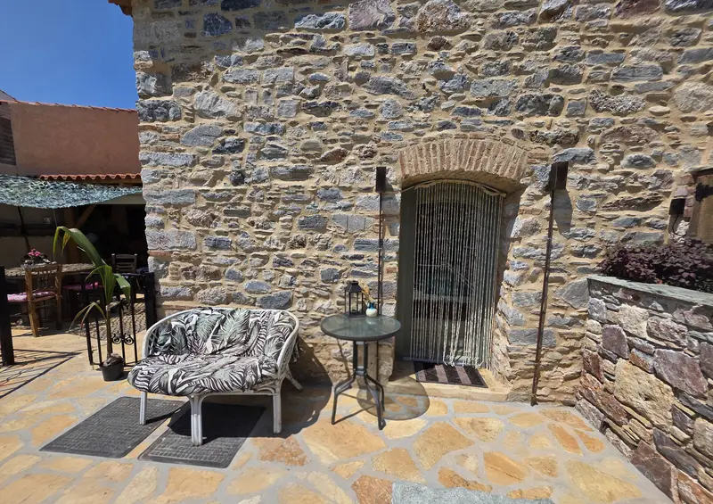 Bench with cushions against the stone facade, beside the iron door
