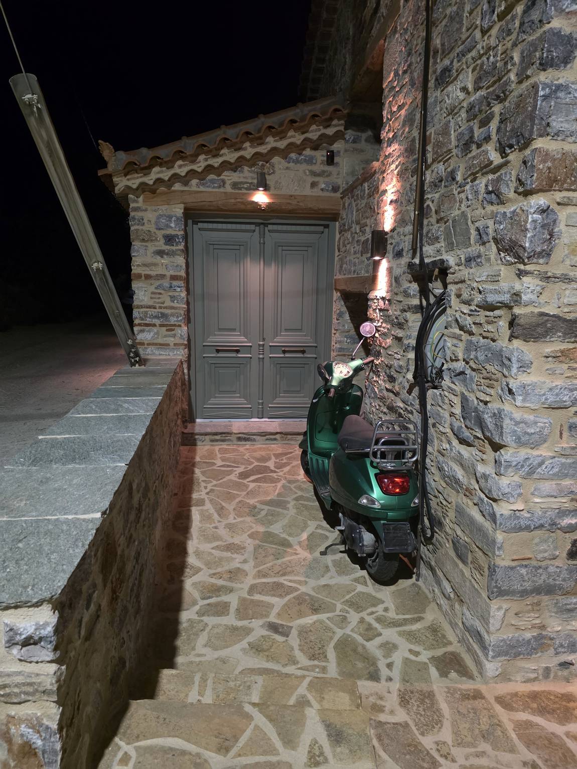 The grey double front door with flagstones in front